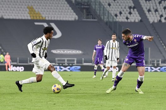  TURIN, ITALY - DECEMBER 22: Juan Cuadrado of Juventus competes for the ball with Cristiano Biraghi of ACF Fiorentina during the Serie A match between Juventus and ACF Fiorentina at Allianz Stadium on December 22, 2020 in Turin, Italy. Sporting stadiums around Italy remain under strict restrictions due to the Coronavirus Pandemic as Government social distancing laws prohibit fans inside venues resulting in games being played behind closed doors. (Photo by Daniele Badolato - Juventus FC/Juventus FC via Getty Images) 