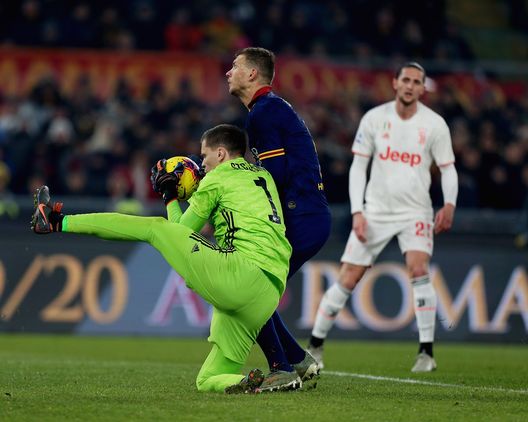 ROME, ITALY - JANUARY 12: Juventus goalkeeper Wojciech Szczesny competes for the ball with Edin Dzeko of AS Roma during the Serie A match between AS Roma and Juventus at Stadio Olimpico on January 12, 2020 in Rome, Italy. (Photo by Paolo Bruno/Getty Images) ROME, ITALY - JANUARY 12: Juventus goalkeeper Wojciech Szczesny competes for the ball with Edin Dzeko of AS Roma during the Serie A match between AS Roma and Juventus at Stadio Olimpico on January 12, 2020 in Rome, Italy. (Photo by Paolo Bruno/Getty Images)