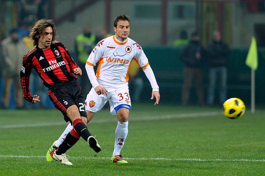 MILAN, ITALY - DECEMBER 18:  Andrea Pirlo (L) of AC Milan competes for the ball with Matteo Brighi of AS Roma during the Serie A match between AC Milan and AS Roma at Stadio Giuseppe Meazza on December 18, 2010 in Milan, Italy.  (Photo by Claudio Villa/Getty Images) 