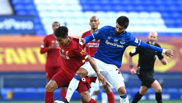 LIVERPOOL, ENGLAND - JUNE 21: Roberto Firmino of Liverpool battles for possession with Andre Gomes of Everton during the Premier League match between Everton FC and Liverpool FC at Goodison Park on June 21, 2020 in Liverpool, England. Football Stadiums around Europe remain empty due to the Coronavirus Pandemic as Government social distancing laws prohibit fans inside venues resulting in all fixtures being played behind closed doors. (Photo by Shaun Botterill/Getty Images) 