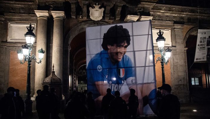 NAPLES, ITALY - NOVEMBER 26: A parade of supporters in Piazza del Plebiscito, where a choreography with red smoke bombs was set up to remember Diego Armando Maradona on November 26, 2020 in Naples, Italy. Diego Armando Maradona died at 60 after a cardiocirculatory arrest while he was at his house in Tigre, Argentina, where he was spending his convalescence after brain surgery three weeks before. (Photo by Ivan Romano/Getty Images) NAPLES, ITALY - NOVEMBER 26: A parade of supporters in Piazza del Plebiscito, where a choreography with red smoke bombs was set up to remember Diego Armando Maradona on November 26, 2020 in Naples, Italy. Diego Armando Maradona died at 60 after a cardiocirculatory arrest while he was at his house in Tigre, Argentina, where he was spending his convalescence after brain surgery three weeks before. (Photo by Ivan Romano/Getty Images)