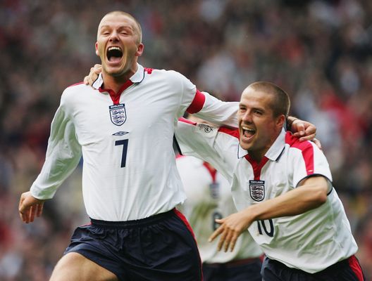 MANCHESTER, ENGLAND - OCTOBER 9: David Beckham of England celebraytes his goal with Michael Owen during the 2006 World Cup Qualifying match between England and Wales at Ols Trafford, on October 9, 2004 in Manchester, England. (Photo by Laurence Griffiths/Getty Images) Qatar, Beckham punta sull’Inghilterra: “Si gioca a metà stagione, saremo freschi è una grande opportunità”- immagine 2