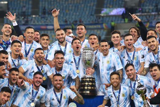 RIO DE JANEIRO, BRAZIL - JULY 10: Lionel Messi and Angel Di Maria of Argentina along with teammates pose with the trophy after winning the final of Copa America Brazil 2021 between Brazil and Argentina at Maracana Stadium on July 10, 2021 in Rio de Janeiro, Brazil. (Photo by Buda Mendes/Getty Images) RIO DE JANEIRO, BRAZIL - JULY 10: Lionel Messi and Angel Di Maria of Argentina along with teammates pose with the trophy after winning the final of Copa America Brazil 2021 between Brazil and Argentina at Maracana Stadium on July 10, 2021 in Rio de Janeiro, Brazil. (Photo by Buda Mendes/Getty Images)