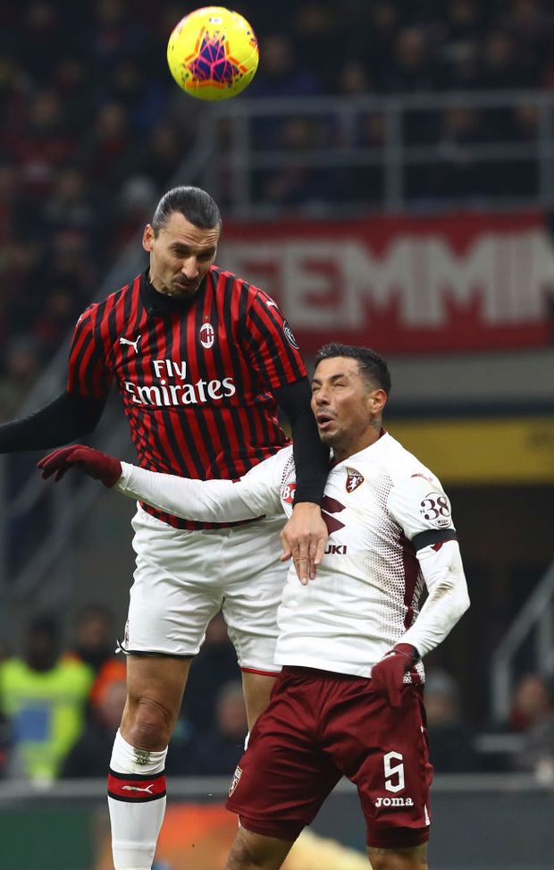  MILAN, ITALY - JANUARY 28: Zlatan Ibrahimovic of AC Milan jumps with Armando Izzo of Torino FC for the ball during the Coppa Italia Quarter Final match between AC Milan and Torino at San Siro on January 28, 2020 in Milan, Italy. (Photo by Marco Luzzani/Getty Images) 