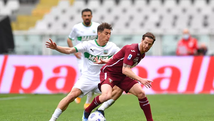 TURIN, ITALY - MARCH 17: Cristian Ansaldi of Torino F.C. is challenged by Filip Djuricic of Sassuolo during the Serie A match between Torino FC and US Sassuolo at Stadio Olimpico di Torino on March 17, 2021 in Turin, Italy. Sporting stadiums around Italy remain under strict restrictions due to the Coronavirus Pandemic as Government social distancing laws prohibit fans inside venues resulting in games being played behind closed doors. (Photo by Valerio Pennicino/Getty Images)