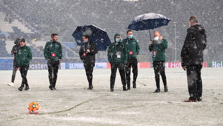 BERGAMO, ITALY - DECEMBER 08: Match officials inspect the pitch with the Adidas winter orange match ball as snow falls prior to the UEFA Champions League group F match between Atalanta and Villarreal CF at Gewiss Stadium on December 08, 2021 in Bergamo, Italy. (Photo by Emilio Andreoli/Getty Images) BERGAMO, ITALY - DECEMBER 08: Match officials inspect the pitch with the Adidas winter orange match ball as snow falls prior to the UEFA Champions League group F match between Atalanta and Villarreal CF at Gewiss Stadium on December 08, 2021 in Bergamo, Italy. (Photo by Emilio Andreoli/Getty Images)