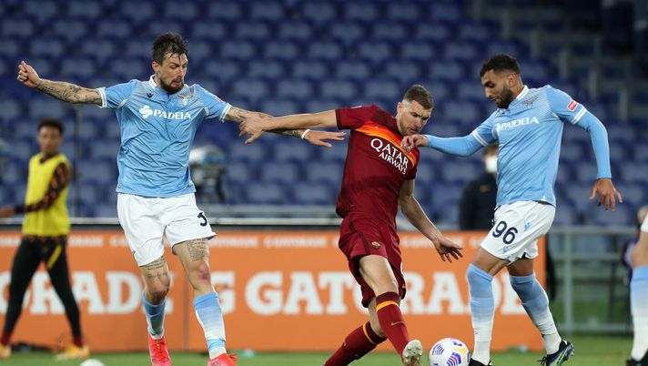 ROME, ITALY - MAY 15: Edin Dzeko of Roma is challenged by Mohamed Fares and Francesco Acerbi during the Serie A match between AS Roma and SS Lazio at Stadio Olimpico on May 15, 2021 in Rome, Italy. Sporting stadiums around Italy remain under strict restrictions due to the Coronavirus Pandemic as Government social distancing laws prohibit fans inside venues resulting in games being played behind closed doors. (Photo by Paolo Bruno/Getty Images) ROME, ITALY - MAY 15: Edin Dzeko of Roma is challenged by Mohamed Fares and Francesco Acerbi during the Serie A match between AS Roma and SS Lazio at Stadio Olimpico on May 15, 2021 in Rome, Italy. Sporting stadiums around Italy remain under strict restrictions due to the Coronavirus Pandemic as Government social distancing laws prohibit fans inside venues resulting in games being played behind closed doors. (Photo by Paolo Bruno/Getty Images)