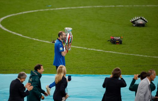 Giorgio Chiellini che tiene la coppa di Euro 2020 tra le mani circondato dai fotografi Giorgio Chiellini che tiene la coppa di Euro 2020 tra le mani circondato dai fotografi