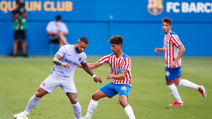 BARCELONA, SPAIN - JULY 24: Memphis Depay of FC Barcelona challenges for the ball against Ilyas Saira of Girona FC during the pre-season friendly match between FC Barcelona and Girona at Estadi Johan Cruyff on July 24, 2021 in Barcelona, Spain. (Photo by Eric Alonso/Getty Images) 