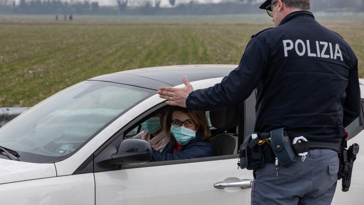 CASALPUSTERLENGO, ITALY - FEBRUARY 23: An Italian National Police officer talks to a driver in a car, wearing a respiratory mask, on February 23, 2020 in Casalpusterlengo, south-west Milan, Italy. Casalpusterlengo is one of the ten small towns placed under lockdown earlier this morning as a second death from coronavirus sparked fears throughout the Lombardy region. (Photo by Emanuele Cremaschi/Getty Images) CASALPUSTERLENGO, ITALY - FEBRUARY 23: An Italian National Police officer talks to a driver in a car, wearing a respiratory mask, on February 23, 2020 in Casalpusterlengo, south-west Milan, Italy. Casalpusterlengo is one of the ten small towns placed under lockdown earlier this morning as a second death from coronavirus sparked fears throughout the Lombardy region. (Photo by Emanuele Cremaschi/Getty Images)