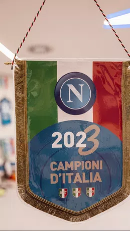 Il Napoli è pronto a scendere in campo per la sua ultima partita stagionale. Questo pomeriggio scenderanno in campo con una maglia speciale, ma anche un gagliardetto che omaggia i campioni d'Italia