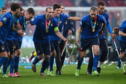 LONDON, ENGLAND - JULY 11: Giorgio Chiellini and Leonardo Bonucci of Italy celebrate with their teammates and The Henri Delaunay Trophy following their team's victory in the UEFA Euro 2020 Championship Final between Italy and England at Wembley Stadium on July 11, 2021 in London, England. (Photo by Andy Rain - Pool/Getty Images) LONDON, ENGLAND - JULY 11: Giorgio Chiellini and Leonardo Bonucci of Italy celebrate with their teammates and The Henri Delaunay Trophy following their team's victory in the UEFA Euro 2020 Championship Final between Italy and England at Wembley Stadium on July 11, 2021 in London, England. (Photo by Andy Rain - Pool/Getty Images)