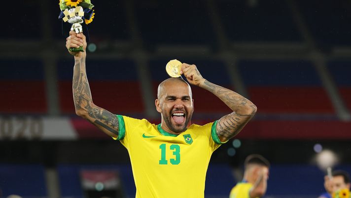 YOKOHAMA, JAPAN - AUGUST 07: Gold medalist Dani Alves #13 of Team Brazil celebrates with their gold medal during the Men's Football Competition Medal Ceremony on day fifteen of the Tokyo 2020 Olympic Games at International Stadium Yokohama on August 07, 2021 in Yokohama, Kanagawa, Japan. (Photo by Francois Nel/Getty Images) YOKOHAMA, JAPAN - AUGUST 07: Gold medalist Dani Alves #13 of Team Brazil celebrates with their gold medal during the Men's Football Competition Medal Ceremony on day fifteen of the Tokyo 2020 Olympic Games at International Stadium Yokohama on August 07, 2021 in Yokohama, Kanagawa, Japan. (Photo by Francois Nel/Getty Images)