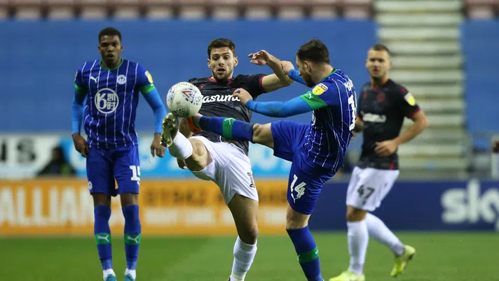 WIGAN, ENGLAND - NOVEMBER 30: Joe Garner of Wigan Athletic tackles Lucas Boye of Reading FC during the Sky Bet Championship match between Wigan Athletic and Reading at DW Stadium on November 30, 2019 in Wigan, England. (Photo by Charlotte Tattersall/Getty Images)