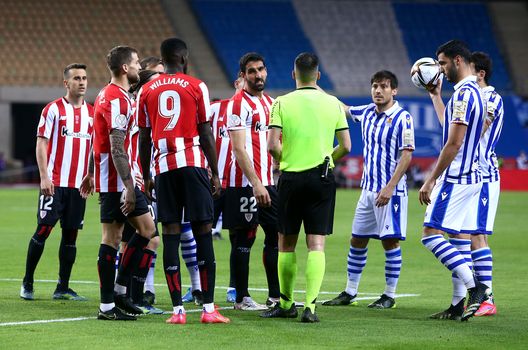 SEVILLE, SPAIN - APRIL 03: Rauel Garcia of Athletic Bilbao, David Silva of Real Sociedad and teammates from both teams surround Match Referee Xavier Estrada Fernandez during the Copa Del Rey Final match between Real Sociedad and Athletic Club at Estadio de La Cartuja on April 03, 2021 in Seville, Spain. Sporting stadiums around Spain remain under strict restrictions due to the Coronavirus Pandemic as Government social distancing laws prohibit fans inside venues resulting in games being played behind closed doors. (Photo by Fran Santiago/Getty Images) SEVILLE, SPAIN - APRIL 03: Rauel Garcia of Athletic Bilbao, David Silva of Real Sociedad and teammates from both teams surround Match Referee Xavier Estrada Fernandez during the Copa Del Rey Final match between Real Sociedad and Athletic Club at Estadio de La Cartuja on April 03, 2021 in Seville, Spain. Sporting stadiums around Spain remain under strict restrictions due to the Coronavirus Pandemic as Government social distancing laws prohibit fans inside venues resulting in games being played behind closed doors. (Photo by Fran Santiago/Getty Images)