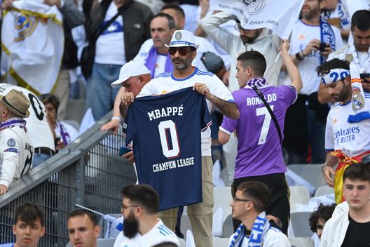PARIS, FRANCE - MAY 28: A Real Madrid fan holding a shirt with the text 'Mbappe 0 Champions League' looks on prior to the UEFA Champions League final match between Liverpool FC and Real Madrid at Stade de France on May 28, 2022 in Paris, France. (Photo by David Ramos/Getty Images) I tifosi del Real non perdonano Mbappé. Allo Stade de France una maglia con dedica… “0 champions” - immagine 1