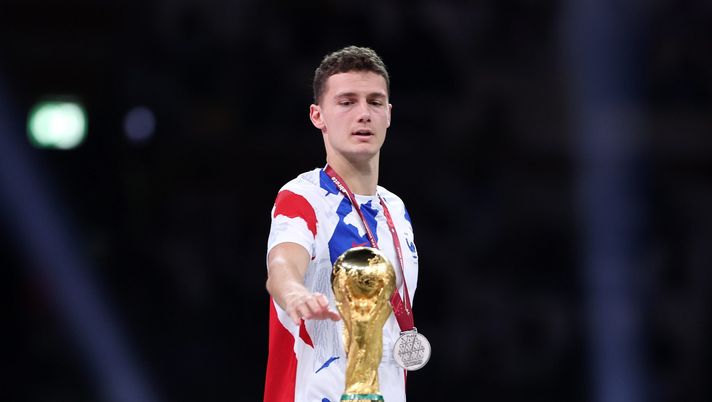 LUSAIL CITY, QATAR - DECEMBER 18: Benjamin Pavard of France touches the FIFA World Cup Qatar 2022 Winner's Trophy during the awards ceremony after the FIFA World Cup Qatar 2022 Final match between Argentina and France at Lusail Stadium on December 18, 2022 in Lusail City, Qatar. (Photo by Clive Brunskill/Getty Images) Francia, spogliatoio tossico e…persino la talpa: Pavard sotto accusa per aver rivelato le magagne… - immagine 1