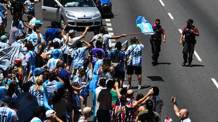 BUENOS AIRES, ARGENTINA - DECEMBER 20: Police officers give instructions to fans of Argentina not to interrupt traffic as they celebrate in General Paz avenue as they wait for the victory parade of the Argentina men's national football team after winning the FIFA World Cup Qatar 2022 on December 20, 2022 in Buenos Aires, Argentina. Due to security reasons amid the a multitude of fans that collapsed the highways, the route of the open-top bus carrying the Argentina national team for the parade was interrupted. It is estimated more than 4 million fans arrived to the highways and streets. (Photo by Rodrigo Valle/Getty Images) BAGNO DI FOLLA ARGENTINA