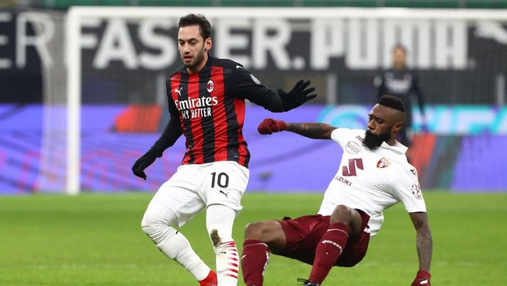 MILAN, ITALY - JANUARY 12: Hakan Calhanoglu of Milan is challenged by Nicolas Nkoulou of Torino during the Coppa Italia match between AC Milan and Torino FC at Stadio Giuseppe Meazza on January 12, 2021 in Milan, Italy. Sporting stadiums around Italy remain under strict restrictions due to the Coronavirus Pandemic as Government social distancing laws prohibit fans inside venues resulting in games being played behind closed doors. (Photo by Marco Luzzani/Getty Images) MILAN, ITALY - JANUARY 12: Hakan Calhanoglu of Milan is challenged by Nicolas Nkoulou of Torino during the Coppa Italia match between AC Milan and Torino FC at Stadio Giuseppe Meazza on January 12, 2021 in Milan, Italy. Sporting stadiums around Italy remain under strict restrictions due to the Coronavirus Pandemic as Government social distancing laws prohibit fans inside venues resulting in games being played behind closed doors. (Photo by Marco Luzzani/Getty Images)