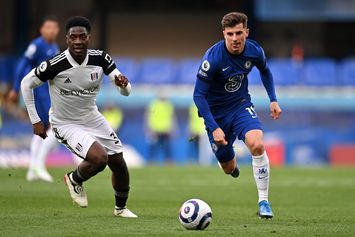  LONDON, ENGLAND - MAY 01: Mason Mount of Chelsea runs with the ball whilst under pressure from Ola Aina of Fulham during the Premier League match between Chelsea and Fulham at Stamford Bridge on May 01, 2021 in London, England. Sporting stadiums around the UK remain under strict restrictions due to the Coronavirus Pandemic as Government social distancing laws prohibit fans inside venues resulting in games being played behind closed doors. (Photo by Justin Setterfield/Getty Images)