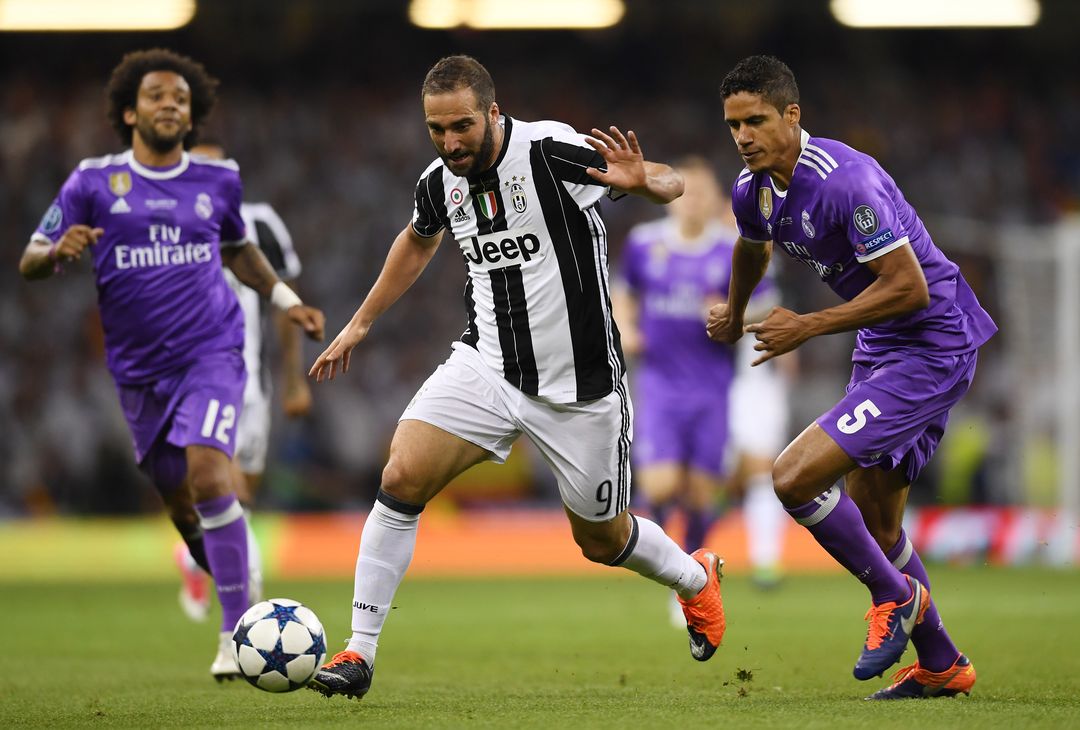  CARDIFF, WALES - JUNE 03:  Gonzalo Higuain of Juventus and Raphael Varane of Real Madrid battle for possession during the UEFA Champions League Final between Juventus and Real Madrid at National Stadium of Wales on June 3, 2017 in Cardiff, Wales.  (Photo by Shaun Botterill/Getty Images) 