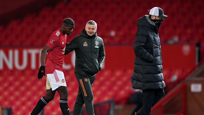 MANCHESTER, ENGLAND - JANUARY 24: Paul Pogba of Manchester United and Ole Gunnar Solskjær, Manager of Manchester United interact as Jurgen Klopp, Manager of Liverpool makes their way across the pitch after The Emirates FA Cup Fourth Round match between Manchester United and Liverpool at Old Trafford on January 24, 2021 in Manchester, England. Sporting stadiums around the UK remain under strict restrictions due to the Coronavirus Pandemic as Government social distancing laws prohibit fans inside venues resulting in games being played behind closed doors. (Photo by Laurence Griffiths/Getty Images) MANCHESTER, ENGLAND - JANUARY 24: Paul Pogba of Manchester United and Ole Gunnar Solskjær, Manager of Manchester United interact as Jurgen Klopp, Manager of Liverpool makes their way across the pitch after The Emirates FA Cup Fourth Round match between Manchester United and Liverpool at Old Trafford on January 24, 2021 in Manchester, England. Sporting stadiums around the UK remain under strict restrictions due to the Coronavirus Pandemic as Government social distancing laws prohibit fans inside venues resulting in games being played behind closed doors. (Photo by Laurence Griffiths/Getty Images)
