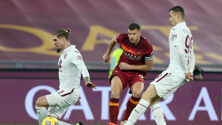 ROME, ITALY - DECEMBER 17: Edin Dzeko of Roma shoots past Lyanco and Alessandro Buongiorno of Torino during the Serie A match between AS Roma and Torino FC at Stadio Olimpico on December 17, 2020 in Rome, Italy. The match will be played without fans, behind closed doors as a Covid-19 precaution. (Photo by Paolo Bruno/Getty Images) ROME, ITALY - DECEMBER 17: Edin Dzeko of Roma shoots past Lyanco and Alessandro Buongiorno of Torino during the Serie A match between AS Roma and Torino FC at Stadio Olimpico on December 17, 2020 in Rome, Italy. The match will be played without fans, behind closed doors as a Covid-19 precaution. (Photo by Paolo Bruno/Getty Images)