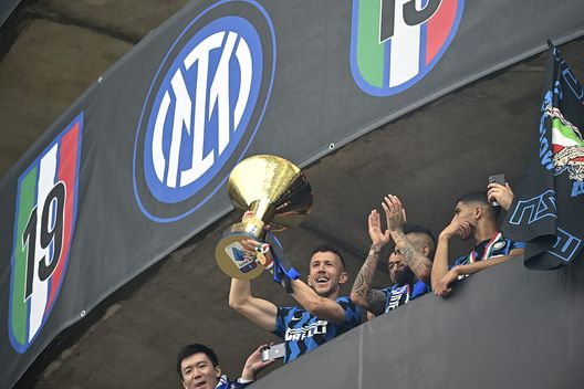  MILAN, ITALY - MAY 23: Ivan Perisic of FC Internazionale lifts the trophy towards the fans who are gathering outside the ground after the Serie A match between FC Internazionale Milano and Udinese Calcio at Stadio Giuseppe Meazza on May 23, 2021 in Milan, Italy. A limited number of fans will be allowed into Premier League stadiums as Coronavirus restrictions begin to ease in Italy. (Photo by Mattia Ozbot/Getty Images) 