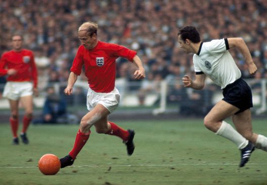 Bobby Charlton of England (left) takes the ball past Franz Beckenbauer of West Germany during the World Cup Final at Wembley Stadium in London on 30th July 1966.  England won 4-2 after extra-time. (Photo by Rolls Press/Popperfoto/Getty Images) 
