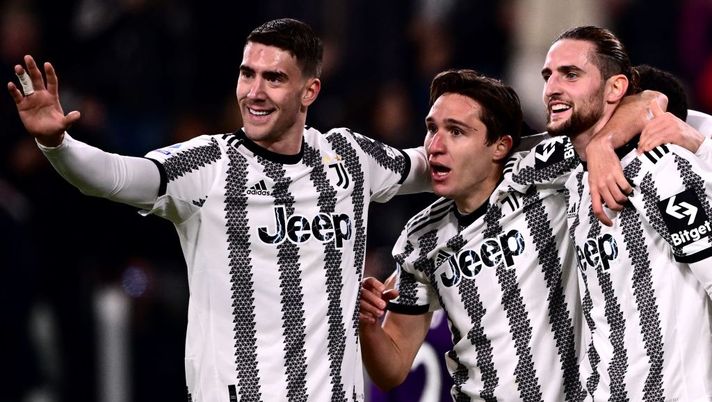 Juventus' French midfielder Adrien Rabiot (R) celebrates with Juventus' Serbian forward Dusan Vlahovic (L) and Juventus' Italian forward Federico Chiesa after opening the scoring during the Italian Serie A football match between Juventus and Fiorentina on February 12, 2023 at the Juventus stadium in Turin. (Photo by Marco BERTORELLO / AFP) (Photo by MARCO BERTORELLO/AFP via Getty Images) Juve, dal dubbio in difesa al tridente con Chiesa: la probabile formazione in Europa - immagine 1