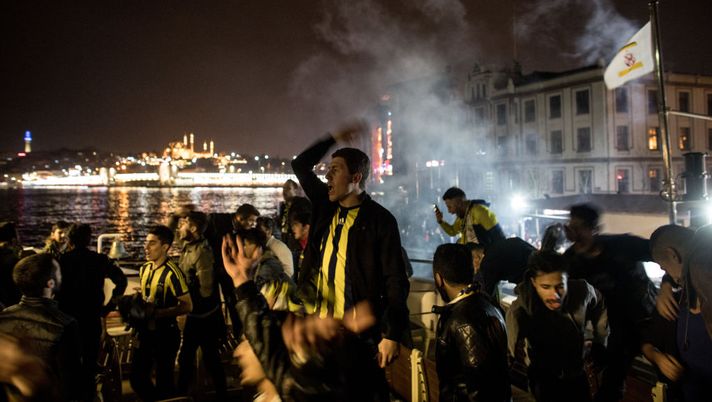 ISTANBUL, TURKEY - MARCH 17: Fenerbahce fans sing songs and wave flares as they ride the ferry back to Istanbul's European side after watching the Istanbul Derby match between Fenerbahce and Galatasaray on March 17, 2018 in Istanbul, Turkey. The Istanbul Derby also known as the Intercontinental Derby is one of footballs fiercest rivalries. Turkey's football fans are some of the most passionate in the world. Fans are forced to travel and enter the stadium separately, with Galatasaray supporters taken to the game on a convoy of buses accompanied by a police escort arriving to a scene of hundreds of riot police standing guard to keep fans seperated. The derby was first played in 1909 and and has often been marred by acts of hooliganism and heavy violence. In 2013 the violence peaked with the stabbing of a 19-year-old Fenerbahce fan after the match. In recent years the efforts of police and fans alike have helped to keep the matches relatively violence free. (Photo by Chris McGrath/Getty Images) ISTANBUL, TURKEY - MARCH 17: Fenerbahce fans sing songs and wave flares as they ride the ferry back to Istanbul's European side after watching the Istanbul Derby match between Fenerbahce and Galatasaray on March 17, 2018 in Istanbul, Turkey. The Istanbul Derby also known as the Intercontinental Derby is one of footballs fiercest rivalries. Turkey's football fans are some of the most passionate in the world. Fans are forced to travel and enter the stadium separately, with Galatasaray supporters taken to the game on a convoy of buses accompanied by a police escort arriving to a scene of hundreds of riot police standing guard to keep fans seperated. The derby was first played in 1909 and and has often been marred by acts of hooliganism and heavy violence. In 2013 the violence peaked with the stabbing of a 19-year-old Fenerbahce fan after the match. In recent years the efforts of police and fans alike have helped to keep the matches relatively violence free. (Photo by Chris McGrath/Getty Images)