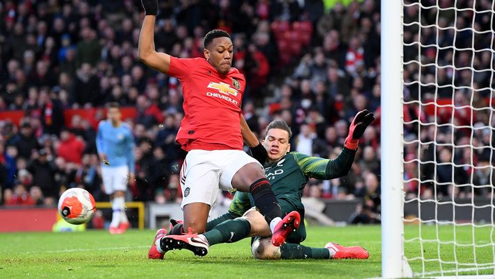 MANCHESTER, ENGLAND - MARCH 08: Ederson of Manchester City clears the ball and collides with Anthony Martial of Manchester United during the Premier League match between Manchester United and Manchester City at Old Trafford on March 08, 2020 in Manchester, United Kingdom. (Photo by Laurence Griffiths/Getty Images) MANCHESTER, ENGLAND - MARCH 08: Ederson of Manchester City clears the ball and collides with Anthony Martial of Manchester United during the Premier League match between Manchester United and Manchester City at Old Trafford on March 08, 2020 in Manchester, United Kingdom. (Photo by Laurence Griffiths/Getty Images)