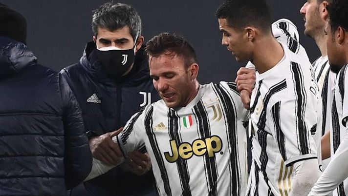 Staff medics (L) and Juventus' Portuguese forward Cristiano Ronaldo (3rdR) tend to Juventus' Brazilian midfielder Arthur (C) after he was injured during the Italian Serie A football match Juventus vs Atalanta on December 16, 2020 at the Juventus stadium in Turin. (Photo by Marco BERTORELLO / AFP) (Photo by MARCO BERTORELLO/AFP via Getty Images) Juve, la data nel mirino di Cuadrado per il rientro. E Arthur rischia l’operazione chirurgica - immagine 1