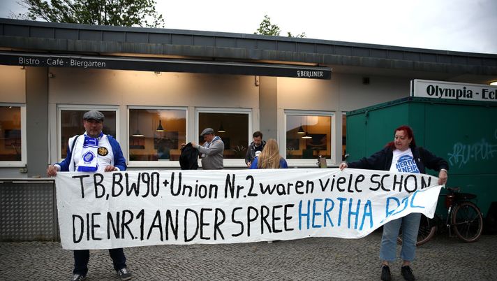 BERLIN, GERMANY - MAY 22: Fans hold up a sign outside the Olympiastadion during the Bundesliga match between Hertha Berlin and Union Berlin during the coronavirus crisis on May 22, 2020 in Berlin, Germany. The Bundesliga, after shutting down all its games in March due to lockdown measures against the spread of the virus, resumed matches last week, albeit in empty stadiums. Fans are mostly watching the games live from home or at the first pubs that have been allowed to reopen. (Photo by Maja Hitij/Getty Images) 