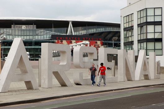 LONDON, ENGLAND - APRIL 11: Two men walk past the sign for Arsenal Football Club's Emirates Stadium on April 11, 2011 in London, England. American businessman Stan Kroenke's company 'Kroenke Sports Enterprises' has increased its shareholding in Arsenal to 62.89% and will make an offer for a full takeover of the club. Mr Kronke first purchased 9.9% of Arsenal shares in 2007, today's deal values the Premier League club at 731m GBP. (Photo by Oli Scarff/Getty Images) LONDON, ENGLAND - APRIL 11: Two men walk past the sign for Arsenal Football Club's Emirates Stadium on April 11, 2011 in London, England. American businessman Stan Kroenke's company 'Kroenke Sports Enterprises' has increased its shareholding in Arsenal to 62.89% and will make an offer for a full takeover of the club. Mr Kronke first purchased 9.9% of Arsenal shares in 2007, today's deal values the Premier League club at 731m GBP. (Photo by Oli Scarff/Getty Images)