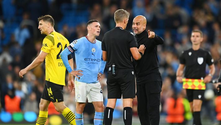 MANCHESTER, ENGLAND - SEPTEMBER 14: Pep Guardiola, Manager of Manchester City interacts with match referee Daniele Orsato after receiving a yellow card during the UEFA Champions League group G match between Manchester City and Borussia Dortmund at Etihad Stadium on September 14, 2022 in Manchester, England. (Photo by Michael Regan/Getty Images) Guardiola e Orsato, “vaffa” in mondovisione e poi l’abbraccio e i tifosi se la ridono: “Dai, lascialo in pace” - immagine 1