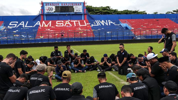 MALANG, INDONESIA - OCTOBER 03: Players and officials of Arema FC mourn as they pay condolence to the victims inside Kanjuruhan Stadium on October 03, 2022 in Malang, Indonesia. A riot and stampede broke out at a football stadium in East Java on Saturday. Police fired tear gas to disperse fans who had invaded the pitch and began fighting after the match ended. A stampede for the exits has resulted in at least 174 deaths, local media reports said, with many still injured in hospitals. (Photo by Ulet Ifansasti/Getty Images) Indonesia, Javier Roca, allenatore dell’Arema: “Non dimenticherò mai, quattro persone morte negli spogliatoi” - immagine 1
