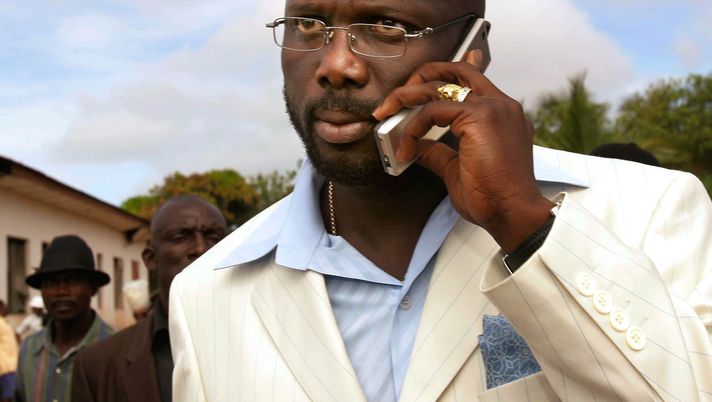 MONROVIA, LIBERIA - OCTOBER 11: Liberian Presidential candidate and international soccer star George Weah talks on a cell phone October 11, 2005 outside a polling place in Monrovia, Liberia. Liberia, beset by 13 years of savage civil war and two years of uncertain peace, held internationally-monitored elections October 11, a landmark achievement after two years of United Nations military occupation. (Photo by Chris Hondros/Getty Images) Presidenti, eurodeputati ministri e dirigenti: il Milan ha fatto anche scuola… politica- immagine 2