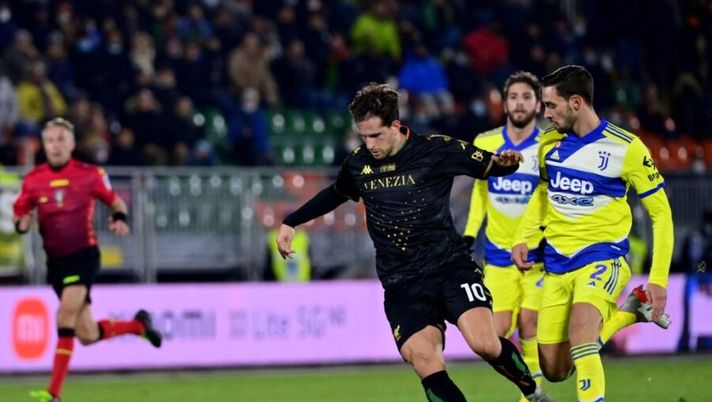 Venezia's Italian forward Mattia Aramu (C) fights for the ball with Juventus' Italian defender Mattia De Sciglio during the Italian Serie A football match between Venezia and Juventus at the Pier Luigi Penzo Stadium in Venice, on December 11, 2021. (Photo by Miguel MEDINA / AFP) (Photo by MIGUEL MEDINA/AFP via Getty Images) Aramu: “Gol da fuori, io ci provo sempre: mi è uscito bene! Perché io tardi in Serie A” - immagine 1