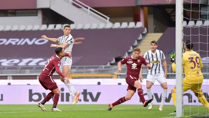TURIN, ITALY - APRIL 03: Cristiano Ronaldo of Juventus heads the ball and Torino's goalkeeper Salvatore Sirigu saves the shot during the Serie A match between Torino FC and Juventus at Stadio Olimpico di Torino on April 03, 2021 in Turin, Italy. Sporting stadiums around Italy remain under strict restrictions due to the Coronavirus Pandemic as Government social distancing laws prohibit fans inside venues resulting in games being played behind closed doors. (Photo by Daniele Badolato - Juventus FC/Juventus FC via Getty Images)