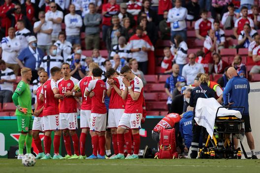 COPENHAGEN, DENMARK - JUNE 12: Players of Denmark stand dejected as Christian Eriksen (Hidden) of Denmark receives medical treatment during the UEFA Euro 2020 Championship Group B match between Denmark and Finland on June 12, 2021 in Copenhagen, Denmark. (Photo by Friedemann Vogel - Pool/Getty Images) 