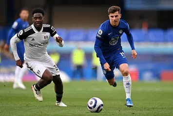  LONDON, ENGLAND - MAY 01: Mason Mount of Chelsea runs with the ball whilst under pressure from Ola Aina of Fulham during the Premier League match between Chelsea and Fulham at Stamford Bridge on May 01, 2021 in London, England. Sporting stadiums around the UK remain under strict restrictions due to the Coronavirus Pandemic as Government social distancing laws prohibit fans inside venues resulting in games being played behind closed doors. (Photo by Justin Setterfield/Getty Images)