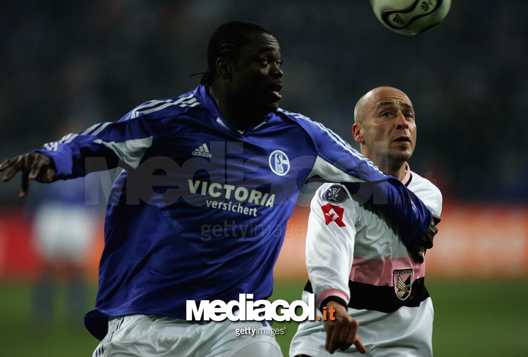 GELSENKIRCHEN, GERMANY - MARCH 16:  Eugenio Corini of Palermo of Palermo and Gerald Asamoah of Schalke go up for a heasder during the UEFA Cup Round of 16 second leg match between Schalke 04 and US Citta di Palermo at the Veltins Arena on March 16, 2006 in Gelsenkirchen, Germany. (Photo by Christof Koepsel/Bongarts/Getty Images) 