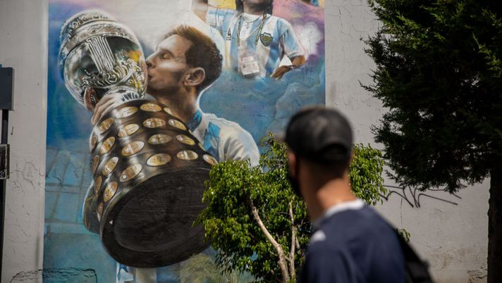 BUENOS AIRES, ARGENTINA - OCTOBER 21: A person looks at a mural depicting Diego Armando Maradona chanting and Lionel Messi holding the Copa America on October 21, 2021 in Buenos Aires, Argentina. Football fans all over the country remember their late idol, who would have turned 61 on October 30. (Photo by Tomas Cuesta/Getty Images) Messi mondiale nel 2022? Maradona lo sapeva: la teoria di un tifoso argentino spopola sul web - immagine 1