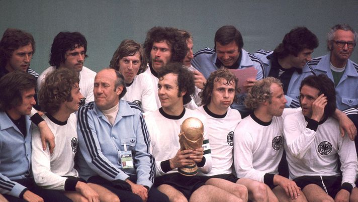 MUNICH, GERMANY - JULY 07: FUSSBALL: WM 1974/Weltmeisterschaft 1974, hintere Reihe v.l.: Heinz FLOHE, Gerd MUELLER, Juergen GRABOWSKI, Paul BREITNER, SCHWARZENBEK, ?, Bernd CULLMANN, ?, vordere Reihe v.l.: Jupp HEYNCKES, Rainer BONHOF, Trainer Helmut SCHOEN, Franz BECKENBAUER (mit Pokal), Bernd HOELZENBEIN, Berti VOGTS, Wolfgang OVERATH (Photo by Bongarts/Getty Images) MUNICH, GERMANY - JULY 07: FUSSBALL: WM 1974/Weltmeisterschaft 1974, hintere Reihe v.l.: Heinz FLOHE, Gerd MUELLER, Juergen GRABOWSKI, Paul BREITNER, SCHWARZENBEK, ?, Bernd CULLMANN, ?, vordere Reihe v.l.: Jupp HEYNCKES, Rainer BONHOF, Trainer Helmut SCHOEN, Franz BECKENBAUER (mit Pokal), Bernd HOELZENBEIN, Berti VOGTS, Wolfgang OVERATH (Photo by Bongarts/Getty Images)