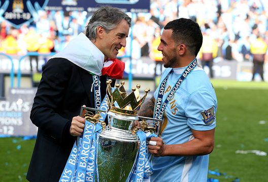 MANCHESTER, ENGLAND - MAY 13: (L-R) Roberto Mancini the manager of Manchester City and Carlos Tevez of Manchester City celebrate with the trophy following the Barclays Premier League match between Manchester City and Queens Park Rangers at the Etihad Stadium on May 13, 2012 in Manchester, England. (Photo by Alex Livesey/Getty Images) MANCHESTER, ENGLAND - MAY 13: (L-R) Roberto Mancini the manager of Manchester City and Carlos Tevez of Manchester City celebrate with the trophy following the Barclays Premier League match between Manchester City and Queens Park Rangers at the Etihad Stadium on May 13, 2012 in Manchester, England. (Photo by Alex Livesey/Getty Images)