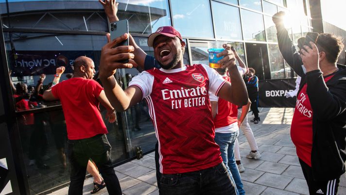 LONDON, ENGLAND - AUGUST 01: Arsenal Football fans celebrate outside Boxpark Wembley as they watch the match from the street through the window as Arsenal wins the FA Cup at Wembley Stadium on August 1, 2020 in London, England. The FA Cup Final is being played behind closed doors at Wembley Stadium this year due to coronavirus restrictions closing off the event for the public to attend. (Photo by Chris J Ratcliffe/Getty Images) LONDON, ENGLAND - AUGUST 01: Arsenal Football fans celebrate outside Boxpark Wembley as they watch the match from the street through the window as Arsenal wins the FA Cup at Wembley Stadium on August 1, 2020 in London, England. The FA Cup Final is being played behind closed doors at Wembley Stadium this year due to coronavirus restrictions closing off the event for the public to attend. (Photo by Chris J Ratcliffe/Getty Images)