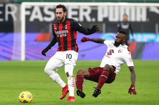 Calhanoglu del Milan protegge il pallone dall'attacco di Nkoulou del Torino Calhanoglu del Milan protegge il pallone dall'attacco di Nkoulou del Torino