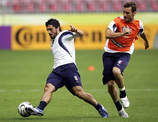 KAISERSLAUTERN, GERMANY - JUNE 25: Gennaro Gattuso (L) vies for the ball with Francesco Totti during an Italy National Football Team training session on June 25, 2006 in Kaiserslautern, Germany. (Photo by Andreas Rentz/Bongarts/Getty Images) Storie di Campioni: notte azzurra in bianco. Gattuso, Totti e la “scopetta” prima della finale del 2006 - immagine 1
