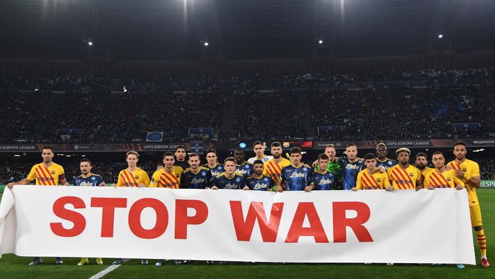 NAPLES, ITALY - FEBRUARY 24: Team members of Napoli and Barcelona hold a banner that reads, "Stop War" during the UEFA Europa League Knockout Round Play-Offs Leg Two match between SSC Napoli and FC Barcelona at Stadio Diego Armando Maradona on February 24, 2022 in Naples, Italy. (Photo by SSC NAPOLI/SSC NAPOLI via Getty Images) Striscione no WAR, nessuna immagine in tv per non coinvolgere l’arbitro di Napoli – Barcellona - immagine 1